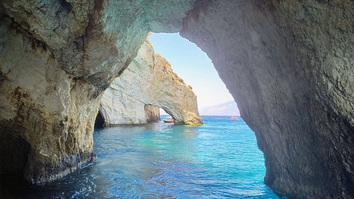 Inside the Blue Caves with sunlight casting an electric blue glow on the water