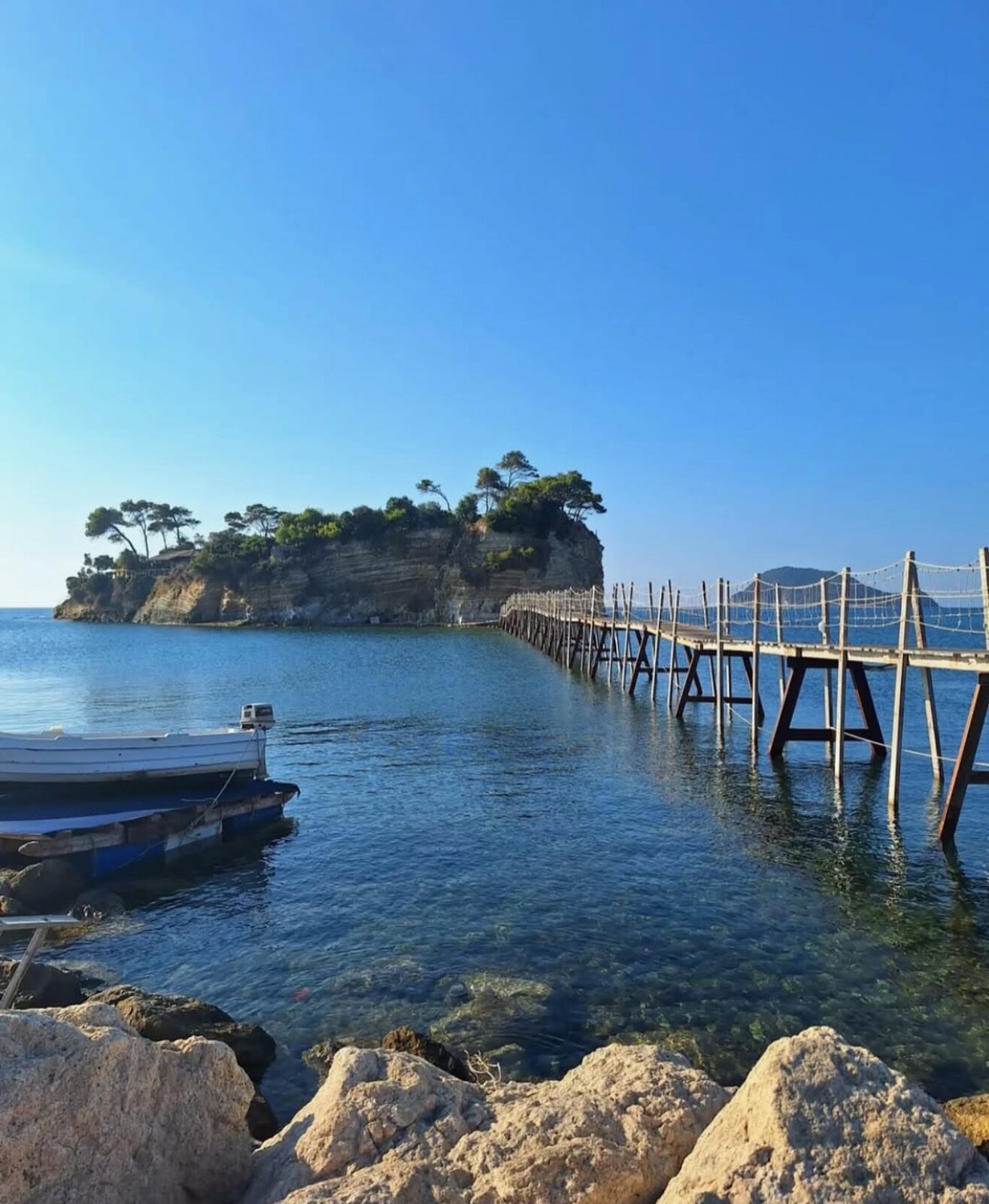 Cameo Island seen from a distance, a small tree-topped islet in Laganas Bay