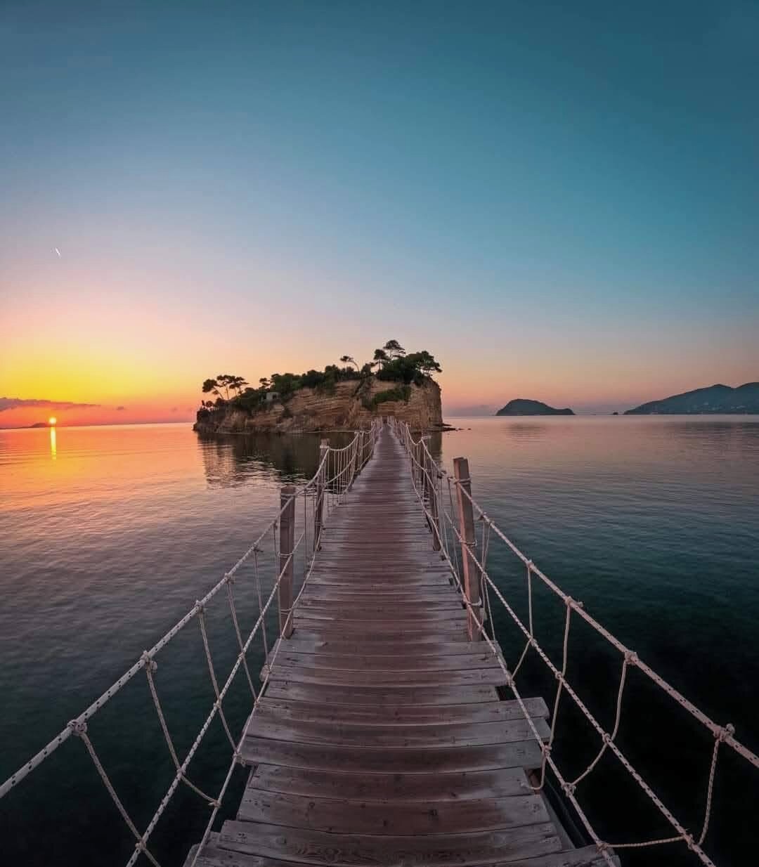 Cameo Island silhouetted at sunset with the wooden bridge in golden light