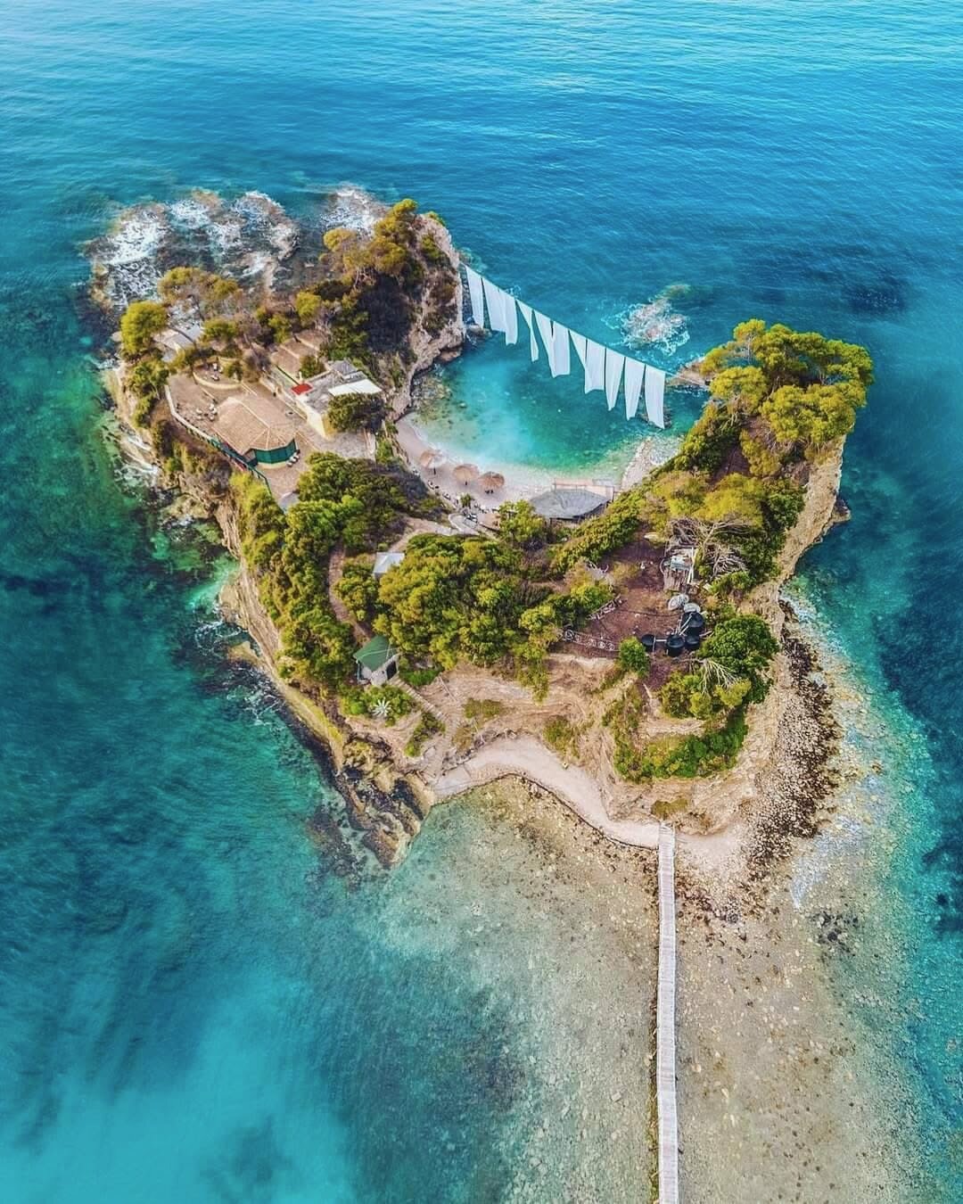 Aerial of the small swimming cove on Cameo Island with white bunting strung above the water