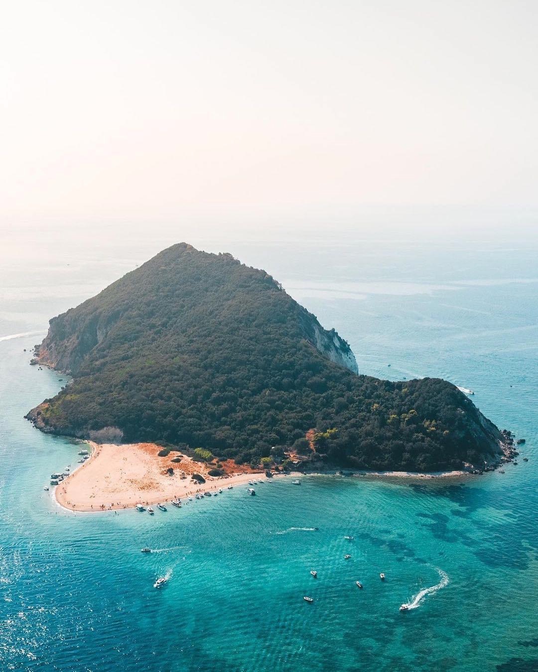 Moody aerial view of Marathonisi Island at dusk with boats in the bay