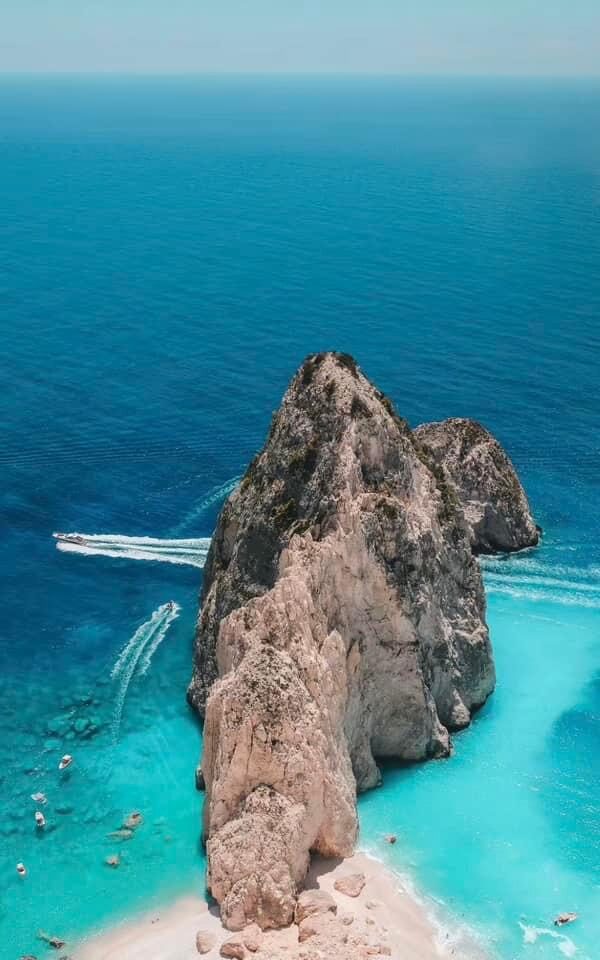 Drone view of boats circling around Myzithres sea stacks