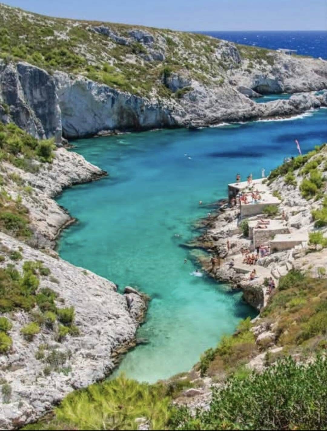 High vantage of the narrow Porto Limnionas inlet with the clifftop taverna terrace on the right