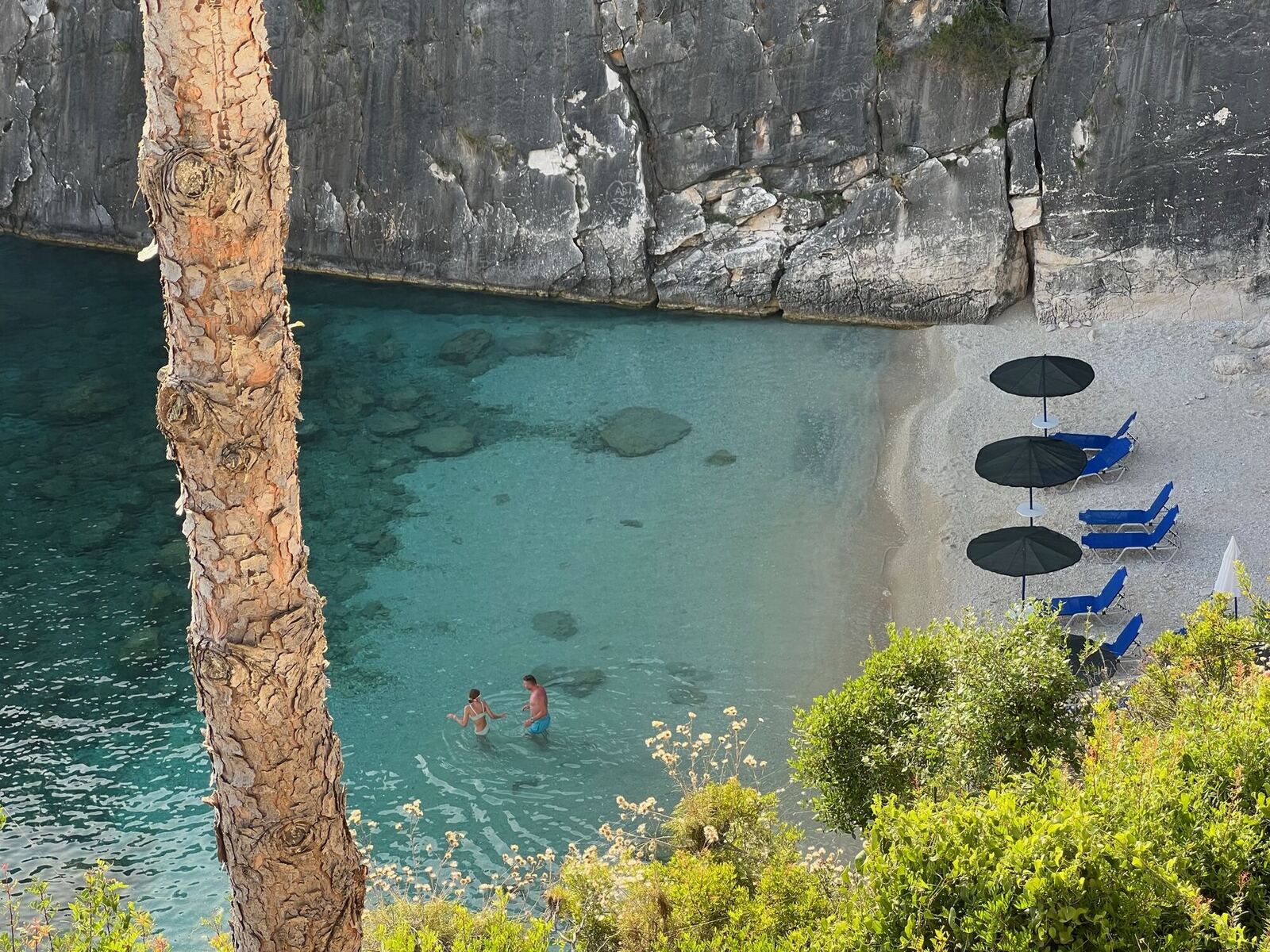 Close-up of swimmers in the mineral-rich waters beneath the cliff at Xigia Beach