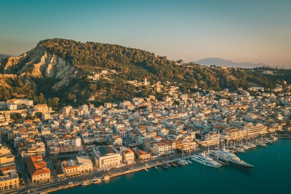 Aerial sunset view of Zakynthos Town with harbour and hillside